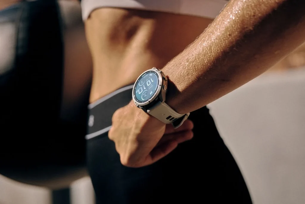 Garmin fenix 9 Pro Solar al polso di un trail runner in montagna con luce piena