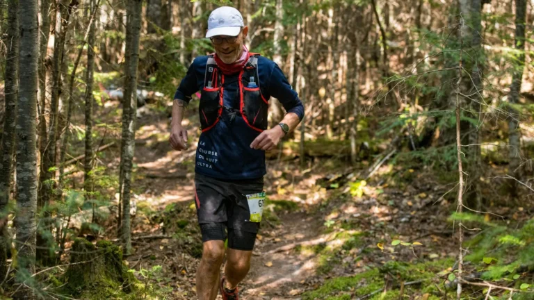 Trailrunner mit Trailrunning-Weste auf einem Waldweg