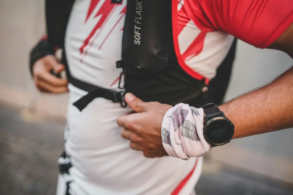 Läufer rückt vor einem Rennen die Soft Flask in der vorderen Tasche seiner Trailrunning-Weste zurecht